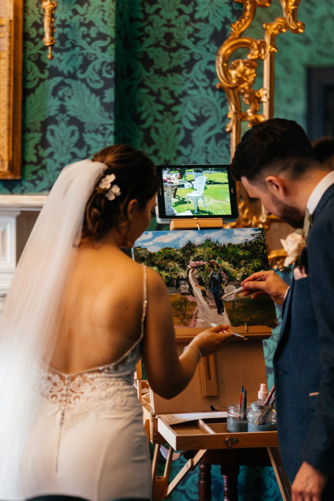 Couple adding their touch to canvas - live wedding painting Ireland
